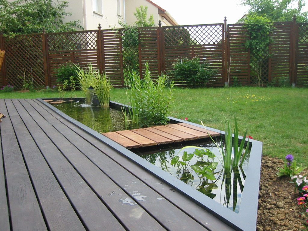 Bassin d'eau avec ponton en bois le long d'une terrasse